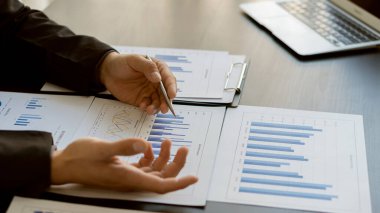 Grafik çizelgelerine işaret eden işadamı veri analizi, veri belgeleri, grafikler, raporlar, piyasa araştırmaları, geliştirme, planlama, yönetim, mali strateji için dizüstü bilgisayar kullanıyor.