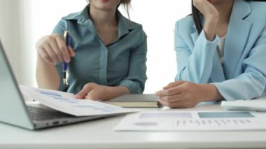 İki Asyalı iş kadını sunumlar, analizler, mali planlama ve istatistikler, ofisteki mali planlama ve istatistik ve yatırım piyasasındaki yeni başlangıç projesi fikirleri hakkında görüştü.