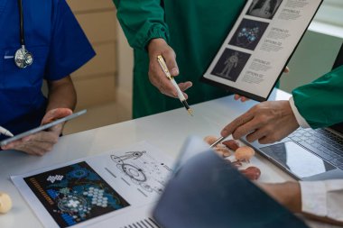 Doktor, hemşire ve stajyer dizüstü bilgisayarla ilgili bilgi arıyor. Ciddi toplantı, göğüs röntgeni filmi Radyoloğu hakkında konuşmak için tıbbi ekip toplantısı.