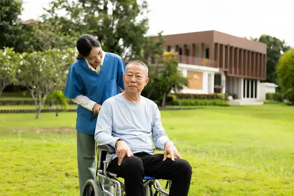 Asian nurse caring for an old man in the garden at home, nurse caregiver supporting health insurance at home or hospital, elderly man