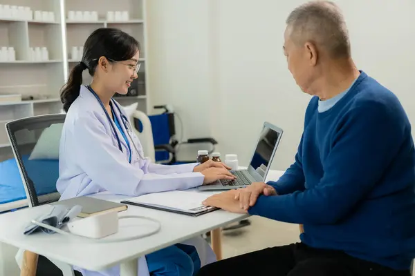 アジアのプロフェッショナル女性医師は 男性患者と話し 彼の痛みと症状について話し 医療病院の検査室でテーブルで相談しました — ストック写真