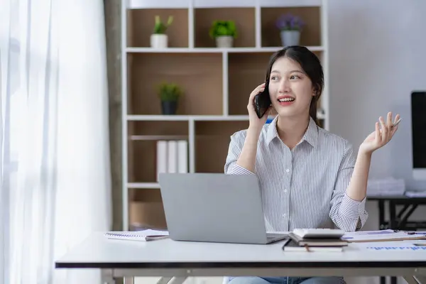 专业的亚洲女性会计师在办公桌前使用计算器和笔记本电脑分析报告和业务文件 专注于她的销售账户 — 图库照片