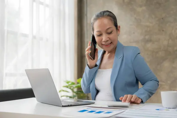 Senior Asijské Podnikatelka Mluví Telefonu Zákazníkem Kanceláři Přičemž Objednávky Prostřednictvím — Stock fotografie