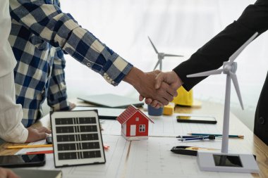 İnşaat ekibinin el sıkışması ile birlikte masa ve ev tasarımı tasarımı tasarımı sarı başlık İnşaat sahası ortağı ve müteahhit ofis merkezinde yeni proje sözleşmesi planı başlat