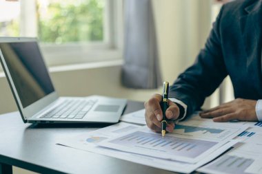 İş muhasebe konsepti İşadamı dizüstü bilgisayar bütçesi ile hesap makinesi kullanır ve ödünç alınmış kağıt harcamaları, harcamalar, online vergiler, şirket bütçeleri, yakın plan resimleri