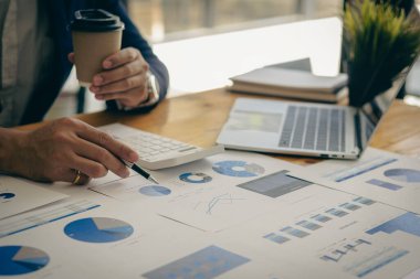 İş muhasebe konsepti İşadamı dizüstü bilgisayar bütçesi ile hesap makinesi kullanır ve ödünç alınmış kağıt harcamaları, harcamalar, online vergiler, şirket bütçeleri, yakın plan resimleri