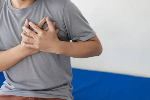 Healthcare concept, A man has severe heart pain and chest pain suffocating.Portrait of man placing hands on the chest suffering from pain in the heart.