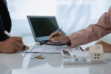 Ev ve arazi satın alma kavramı, ev satın alma sözleşmesi ve kredi anlaşmasını kabul ettikten sonra ev ve anahtarları müşteriye teslim etmektir. Emlakçıyla görüşme, yakın plan fotoğraf.