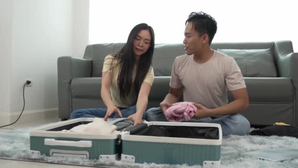Ασιατικό Ζευγάρι Που Πακετάρει Ρούχα Για Ένα Ταξίδι Στο Εξωτερικό — Αρχείο Βίντεο