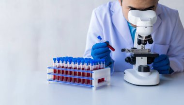 Hastane doktoru laboratuvarda kan damarı testi yaptı. Raftan alınan kan örneğiyle laboratuvarda analiz cihazı bulundu.