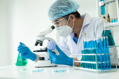 Kendini adamış bilim adamları ilaç, aşı veya antibiyotik geliştirmek için test tüplerindeki tıbbi laboratuvarlarda kimyasal deneyler yapıyorlar. Yakın plan resimler.