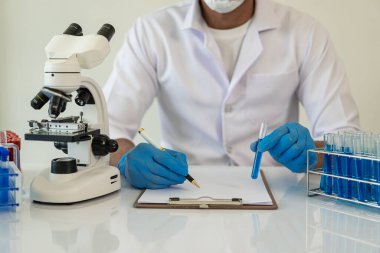 Kendini adamış bilim adamları ilaç, aşı veya antibiyotik geliştirmek için test tüplerindeki tıbbi laboratuvarlarda kimyasal deneyler yapıyorlar. Yakın plan resimler.