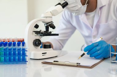 Kendini adamış bilim adamları ilaç, aşı veya antibiyotik geliştirmek için test tüplerindeki tıbbi laboratuvarlarda kimyasal deneyler yapıyorlar. Yakın plan resimler.