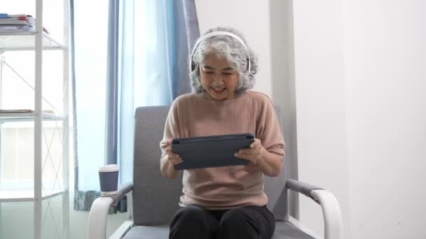 Elderly Asian Woman Grandmother Sitting Sofa Using Tablet Device Write — Stock Video