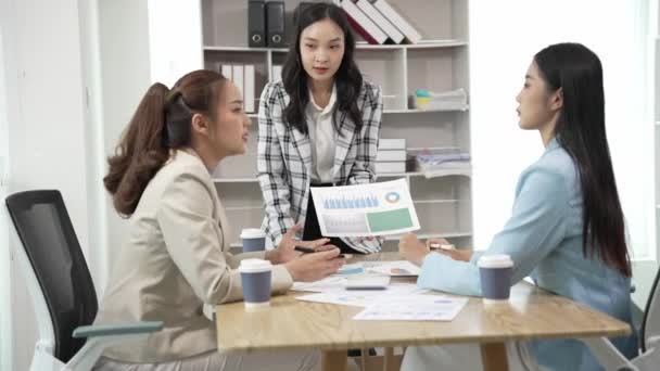 笑顔のアジアのビジネスウーマンは同僚と話し 会議室で笑う女性コンサルタントとノートパソコンを使ってオフィスでアイデアを交換し 新しいビジネスアイデア — ストック動画