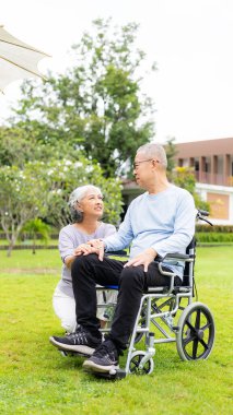 Mutlu Asyalı yaşlı çift tropikal bir orman yolunda birlikte yürüyor emekli yaşlı adam ve kadın eğleniyor ve açık hava seyahatlerinin tadını çıkarıyor. Dikey resim