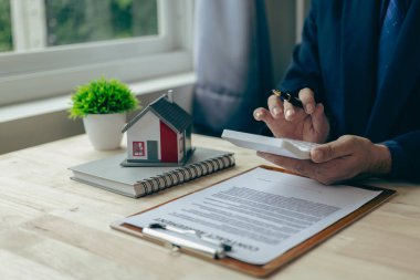 Emlakçı, ev modeli, evin kapanışı, anahtarlar ve masadaki küçük oyuncak evi, avukat, hukuk danışmanı, emlakçı, banka müdürü, mortgage anlaşması.