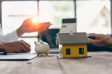 Emlakçı, ev modeli, evin kapanışı, anahtarlar ve masadaki küçük oyuncak evi, avukat, hukuk danışmanı, emlakçı, banka müdürü, mortgage anlaşması.