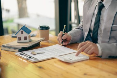Emlakçı, ev modeli, evin kapanışı, anahtarlar ve masadaki küçük oyuncak evi, avukat, hukuk danışmanı, emlakçı, banka müdürü, mortgage anlaşması.