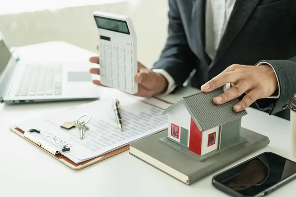 Emlakçı, ev modeli, evin kapanışı, anahtarlar ve masadaki küçük oyuncak evi, avukat, hukuk danışmanı, emlakçı, banka müdürü, mortgage anlaşması.