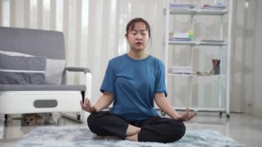 fit vücutlu aktif ve sağlıklı Asyalı kız evde egzersiz yapıyor, dambılları kaldırıyor, yoga yapıyor, yoga minderinde geriniyor ve egzersiz yapıyor. Sağlıklı yaşam tarzı, barış