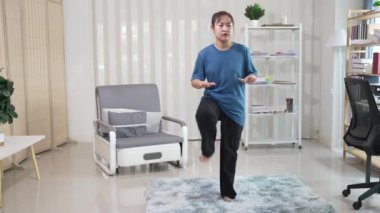 fit vücutlu aktif ve sağlıklı Asyalı kız evde egzersiz yapıyor, dambılları kaldırıyor, yoga yapıyor, yoga minderinde geriniyor ve egzersiz yapıyor. Sağlıklı yaşam tarzı, barış