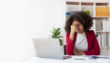 Ofiste başı ağrıyan yorgun bir iş kadını iş yerinde kendini hasta hissediyor çok çalışıyor ve çok geç, ofis sendromu kavramı..