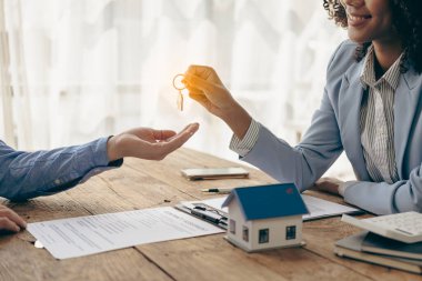 Bir emlakçı ve bir müşteri, emlak ya da emlak için sigorta ya da kredi alma sözleşmesini tartışır. Bir emlakçı el sıkışıyor ve müşteriye örnek veriyor..