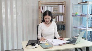 Dizüstü bilgisayarda çalışan ve evrak işleriyle uğraşan kadın muhasebeci, vergiler, ticaret, araştırma, muhasebe ve muhasebe analizleri, gayrimenkul yatırım verileri, finansmanlar
