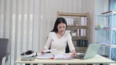 Dizüstü bilgisayarda çalışan ve evrak işleriyle uğraşan kadın muhasebeci, vergiler, ticaret, araştırma, muhasebe ve muhasebe analizleri, gayrimenkul yatırım verileri, finansmanlar