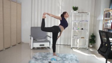 Spor elbiseli Asyalı kadın evde yoga yapıyor, yeni normal yaşam tarzı konsepti, evde oturma odasında dinleniyor. Kişisel izolasyon ve sağlık için egzersiz