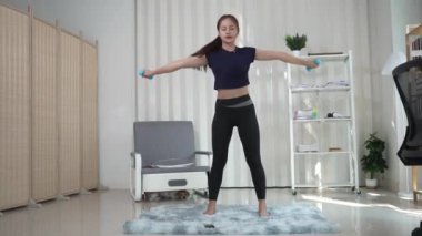 Spor elbiseli Asyalı kadın evde yoga yapıyor, yeni normal yaşam tarzı konsepti, evde oturma odasında dinleniyor. Kişisel izolasyon ve sağlık için egzersiz