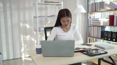 Ofiste çalışan Asyalı güzel bir kadın fotokopi şirketi sahipleri bilgisayar kullanarak online pazarlama yapıyor..