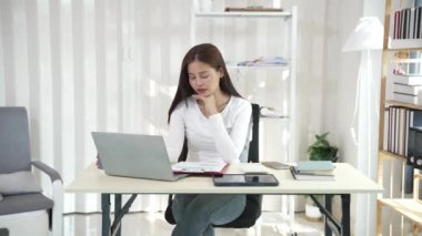 Ofiste çalışan Asyalı güzel bir kadın fotokopi şirketi sahipleri bilgisayar kullanarak online pazarlama yapıyor..