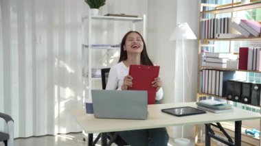 Ofiste çalışan Asyalı güzel bir kadın fotokopi şirketi sahipleri bilgisayar kullanarak online pazarlama yapıyor..