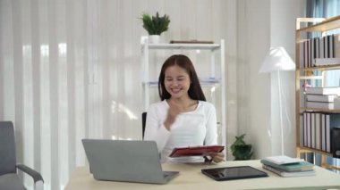 Ofiste çalışan Asyalı güzel bir kadın fotokopi şirketi sahipleri bilgisayar kullanarak online pazarlama yapıyor..