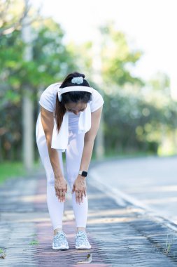 Asya spor parkında sabah sporu yapan güzel bir Asyalı bayan koşucu. Güzellik. Spor kıyafetlerle sıska vücut ısınıyor. Rahatla ve kaslarını esneterek spor yap..