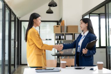 İki Asyalı iş kadını yeni bir proje önerisini tartışıyor. Analiz, planlama ve mali istatistikler, şirket iş ortaklığı kavramı.