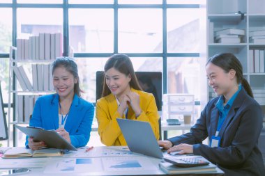 Başarılı Asyalı iş kadını takım toplantısını sunuyor ve ofiste fikirlerini sunuyor.