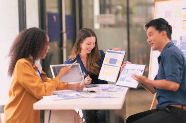 Asyalı başarılı iş adamlarından oluşan bir ekip takım toplantı dakikalarını ve ofis işbirliği fikirlerini sunuyor..