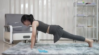 Çekici güzel Asyalı kadın yoga yapıyor, oturma odasında sabah vücut bakımı yapıyor, sağlıklı yaşam tarzı konsepti..