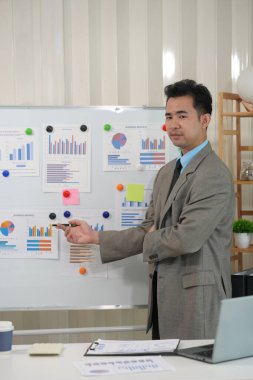 Şirket içindeki harcamalar için Asyalı erkek muhasebeci mali planlama firmasıyla mali belgeleri kontrol edin. Hesap raporlarına göre sayıları hesapla