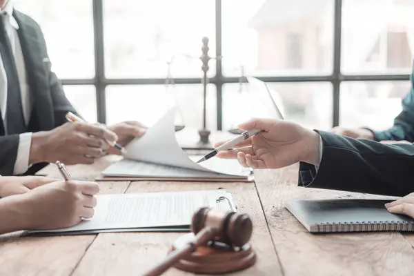 Hukuki anlaşmalar veya finansal raporlar okurken ve not alırken avukatlardan oluşan bir ekip belgeleri inceler ve inceler. Avukatlar çocuklara hukuk hakkında tavsiyelerde bulunurlar. Yakın plan resimler.