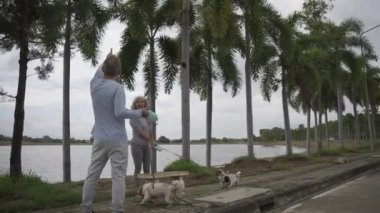 Parkta köpek gezdirme ve egzersiz yapan Asyalı yaşlı çift VDO Siow Hareketi