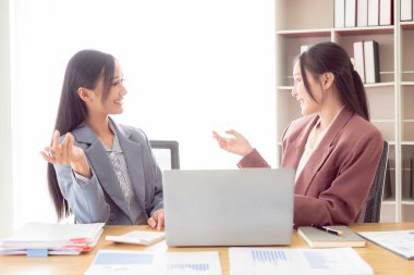 İki Asyalı muhasebeci finansal danışman ya da analistler finansal raporları birlikte tartışıyorlar..