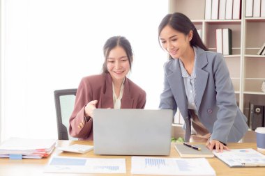 İki Asyalı muhasebeci finansal danışman ya da analistler finansal raporları birlikte tartışıyorlar..