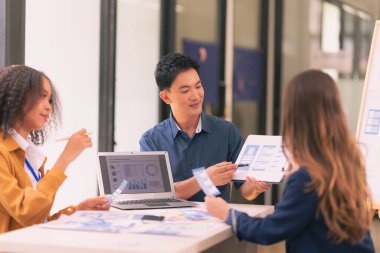 UI UX web tasarımcılarından oluşan bir ekip, modern bir konferans masasında bir projeyi görüşürken / tartışırken mobil bir yanıt veren web sitesi geliştirmek için birlikte çalışıyor. Beyin fırtınası.