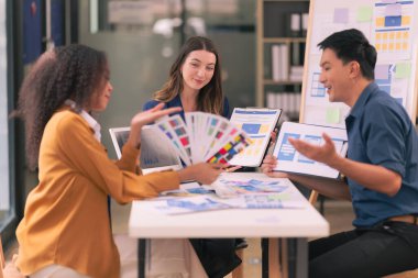 UI UX web tasarımcılarından oluşan bir ekip, modern bir konferans masasında bir projeyi görüşürken / tartışırken mobil bir yanıt veren web sitesi geliştirmek için birlikte çalışıyor. Beyin fırtınası.