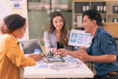 UI UX web tasarımcılarından oluşan bir ekip, modern bir konferans masasında bir projeyi görüşürken / tartışırken mobil bir yanıt veren web sitesi geliştirmek için birlikte çalışıyor. Beyin fırtınası.