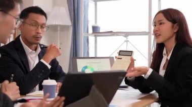 Bir grup iş adamı, finansal stratejiler hakkında konferans odasında dizüstü bilgisayarlarla beyin fırtınası ve pazarlama ve pazarlama analitik dokümanlarını tartışıyor..